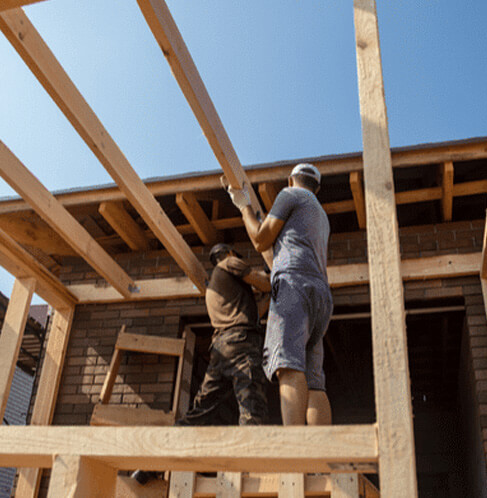 Travaux d’agrandissement de maison avec structure en bois réalisés par des entrepreneurs en construction
